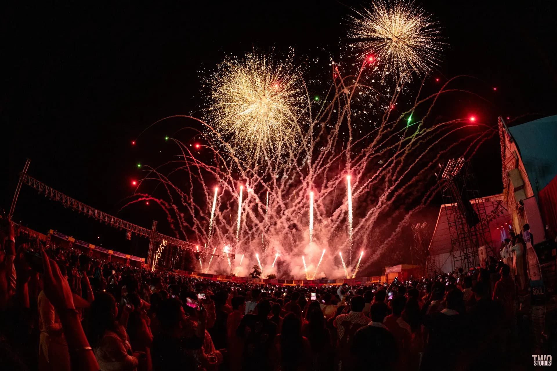 Golden fireworks shells bursting above the grounds as the crowd cheers